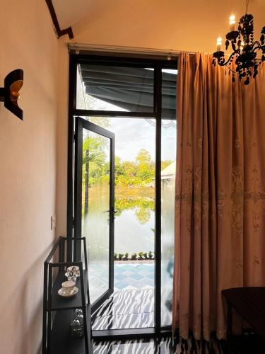 a window with a view of a lake at Cozy breezing countryside Pet in Ban Khlong Sip Sam Lang