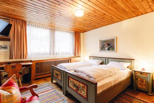 a bedroom with a large bed and a wooden ceiling at Landgasthof Haueis in Marktleugast