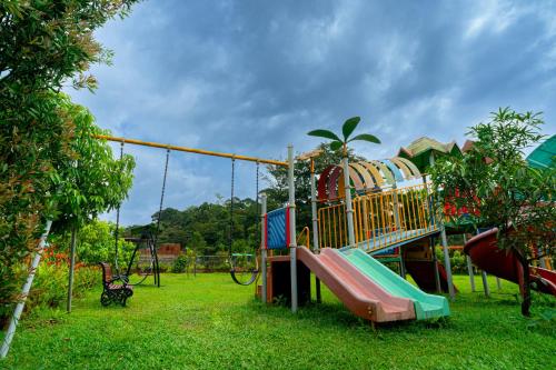 a playground with a slide in the grass at The Sanihara Hotel & Resort in Vythiri