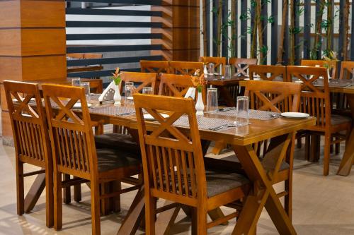 a wooden dining table and chairs in a restaurant at The Sanihara Hotel & Resort in Vythiri