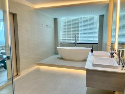 a large bathroom with a tub and a sink at indigo Hotel Hatyai in Ban Kohong