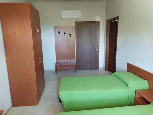a bedroom with two green beds and a closet at Antica Masseria Lo Conte in Ariano Irpino