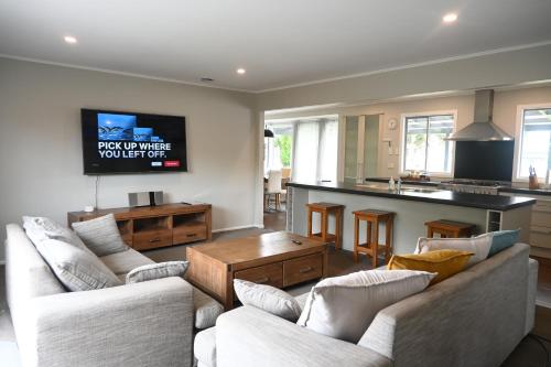 a living room with two couches and a kitchen at New painted 5 bdms spacious house close to the Base in Hamilton