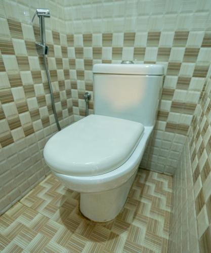 a bathroom with a white toilet in a room at The Sanihara Hotel & Resort in Vythiri