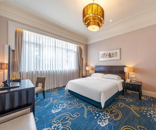 a hotel room with a bed and a television at Hong Qiao State Guest House in Shanghai
