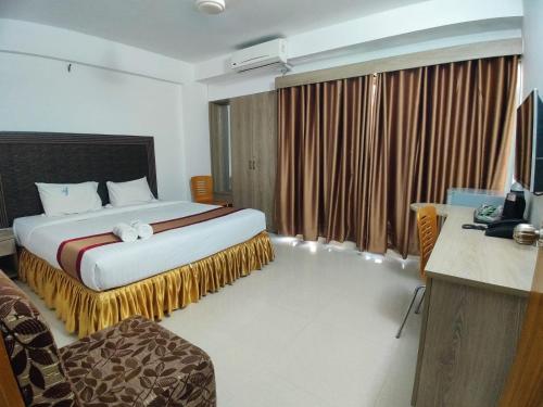 a hotel room with a large bed and a television at Cox West Inn in Cox's Bazar