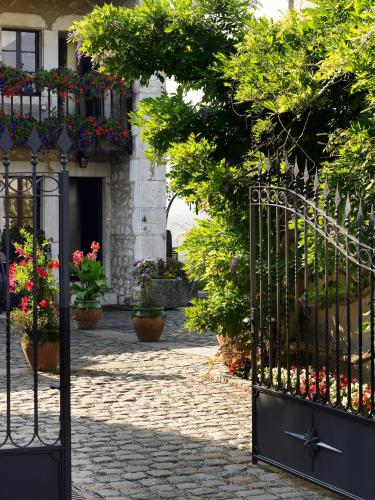 a gate with flowers and plants in front of a building at Domaine de Châteauvieux in Peney-Dessus