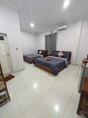 a bedroom with two beds and a couch in it at Orchid 101 in Kampot