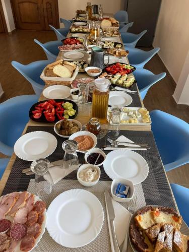 a long table with a long table of food at Casa Hoinarilor Wanderers House in Bran