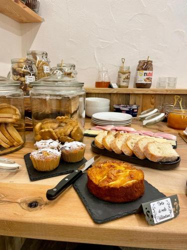 a table with bread and pastries and cupcakes on it at La famille d'Evian in Villeneuve
