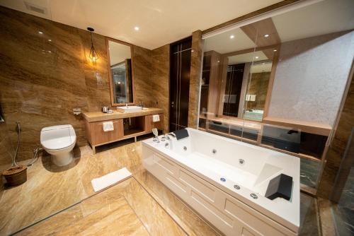 a large bathroom with a tub and a toilet at Taman Prakerti Bhuana Hotel in Gianyar