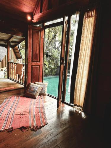 a bedroom with a bed and a large glass door at Resort JUNGLEROOM Canggu in Canggu