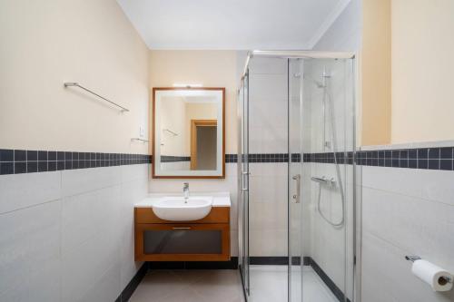 a bathroom with a sink and a shower at Cabanas de Tavira Family Apartment in Cabanas de Tavira