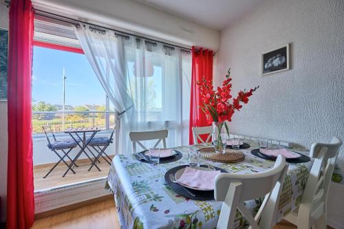 une salle à manger avec une table et un balcon dans l'établissement L'Escale du Cap Horn - Appt 4p à 1km de la mer, à Courseulles-sur-Mer