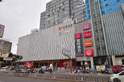 a large building on a city street with cars at Echarm Hotel Kunming Baita Road Huidu International Store in Kunming