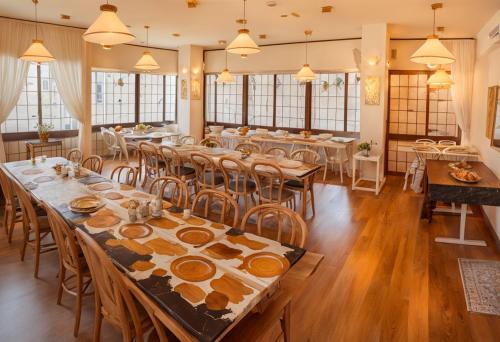 関市にあるSnowHouse Memorie Hotel-汤泽石打丸山-Ski in Ski Outのテーブルと椅子のある広いダイニングルーム