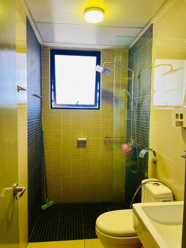 a bathroom with a shower with a toilet and a window at RHFL Homestay Putrajaya in Putrajaya