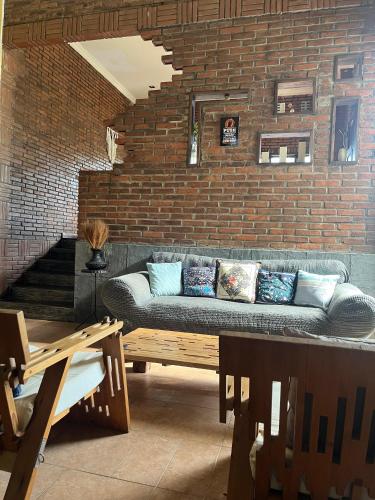 a living room with a couch against a brick wall at D'Kastil Jogja in Cepit