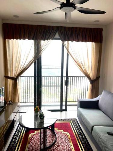 a living room with a couch and a table in front of a large window at Cozy kenwingston platz kl 2-5pax 2BR&2BR Klcc view pakin netflx 3705A in Kuala Lumpur
