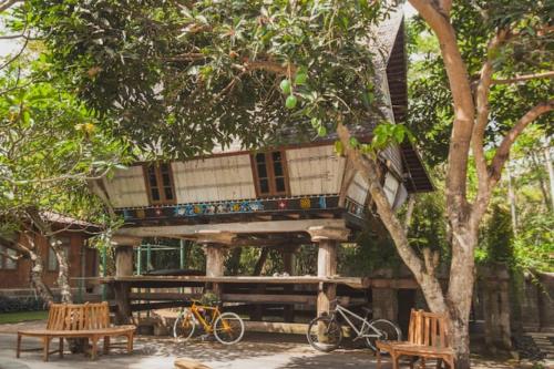 a tree house with two benches and two bikes at Resort JUNGLEROOM Canggu in Canggu