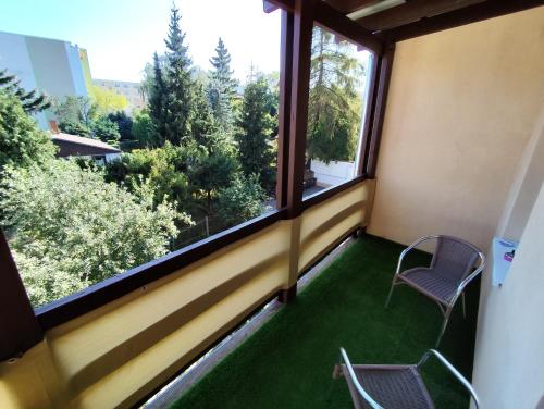 a balcony with a chair and a window with green grass at Cocon Zeitz in Zeitz