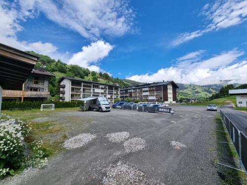 a parking lot with a rv parked in front of buildings at SKILL Mountain Lodge - Ski und Bike Hostel im Sommer mit JOKER CARD in Saalbach Hinterglemm