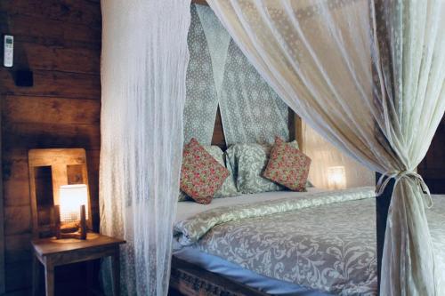 a bedroom with a canopy bed with pillows on it at Resort JUNGLEROOM Canggu in Canggu