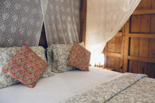 a bed with two pillows on top of it at Resort JUNGLEROOM Canggu in Canggu