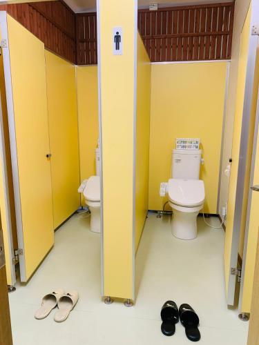 a bathroom with two toilets and shoes in it at Village BFH in Omura