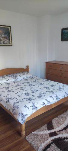 a bedroom with a bed with a blue and white comforter at Apartment Bućić in Zlatibor