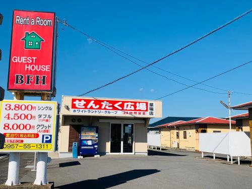 a store with a sign for a guest house at Village BFH in Omura