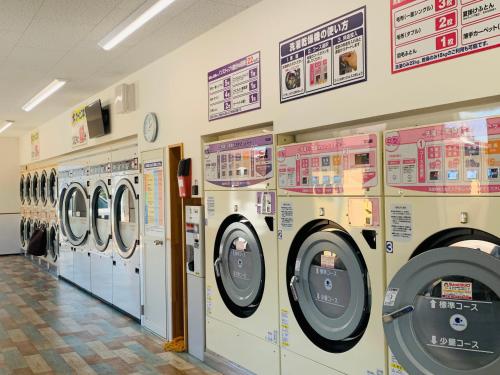a row of washing machines in a laundry room at Village BFH in Omura