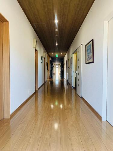 an empty hallway in a building with a wooden ceiling at Village BFH in Omura
