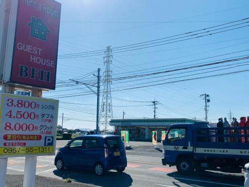 a car parked at a gas station next to a truck at Village BFH in Omura