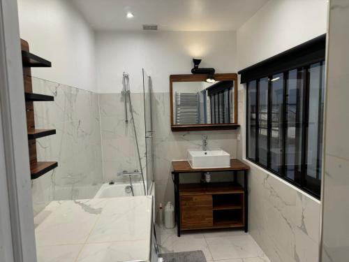 une salle de bain avec une baignoire, un lavabo et une douche dans l'établissement Paris-18, à Paris