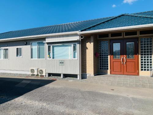 a house with a red door and aphalt at Village BFH in Omura