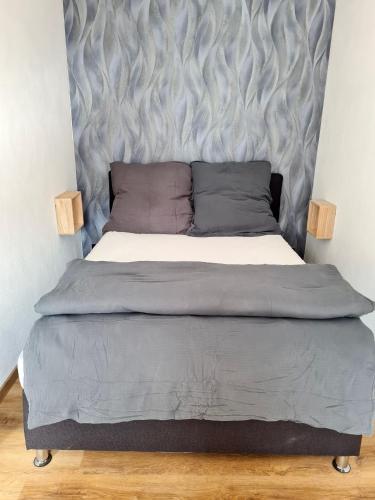 a bed with a gray headboard in a bedroom at Ferienhaus Alex in Gönnersdorf