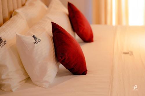 three red and white pillows on a bed at Livin Lush Luxury Retreat in Anuradhapura