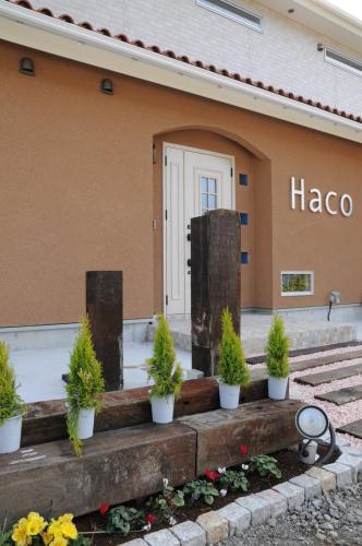 a building with potted plants in front of it at 伊豆高原 記念日を祝う宿 自然家 Haco しぜんや ハコ in Ito