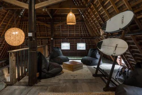 a room with couches in a wooden building at Resort JUNGLEROOM Canggu in Canggu