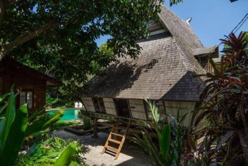 a house with a ladder next to a pool at Resort JUNGLEROOM Canggu in Canggu