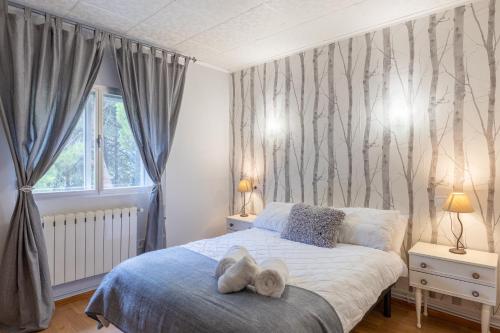 a bedroom with a bed with two towels on it at Cumbre Escondida in Pelayos de la Presa