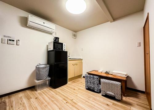 a room with a black refrigerator and a table at 恵美屋 南 in Osaka