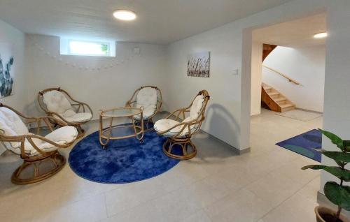 a room with three chairs and a blue rug at Lovely Home In Bolmsö With Sauna in Bolmsö