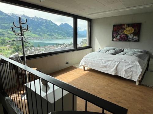a bedroom with a bed and a large window at Maisonette Gäste-Haus vor dem privaten Haupthaus in Sarnen