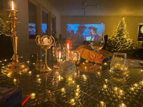 a table topped with wine glasses and a christmas tree at Sjöutsikt, Röd trästuga med traditionellt yttre Skandinavisk, modernt inre och alla bekvämligheter, Sol hela dagen på stora altanen, Tryggt, Vinterbonat, Fiske, Båt in Skinnskatteberg