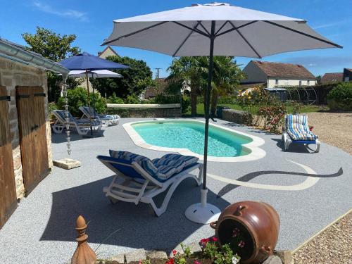 un parasol et des chaises à côté d'une piscine dans l'établissement Le Domaine de L étang La saboterie, à Oeuilly