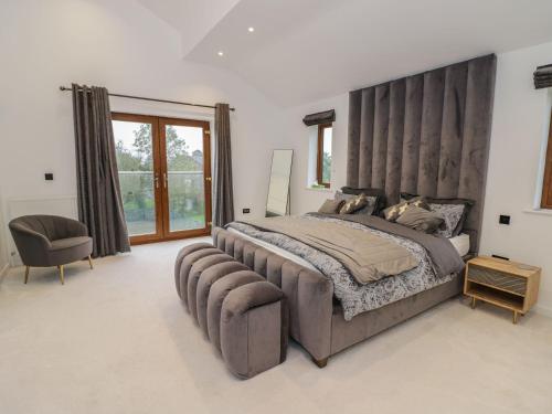 a large bedroom with a large bed and a chair at 85A Braybrooke Road in Kettering