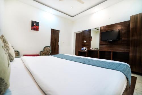 a hotel room with a bed and a tv at The Bunksters Mcleodganj, Dharmkot in McLeod Ganj
