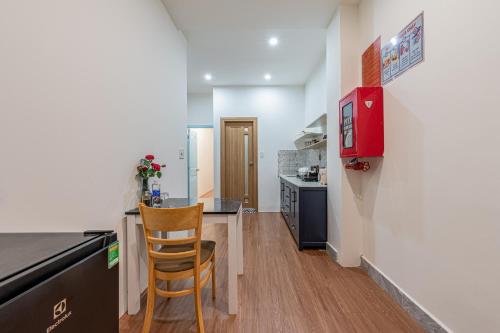 a kitchen with a table and a chair in a room at Palas House By Cozrum in Ho Chi Minh City